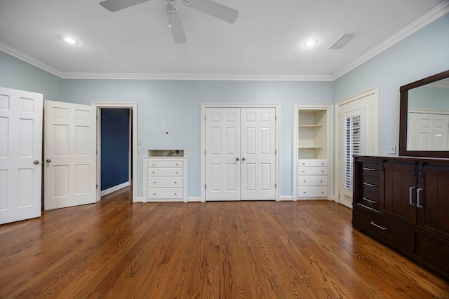 unfurnished bedroom with multiple closets, ceiling fan, ornamental molding, and dark hardwood / wood-style flooring