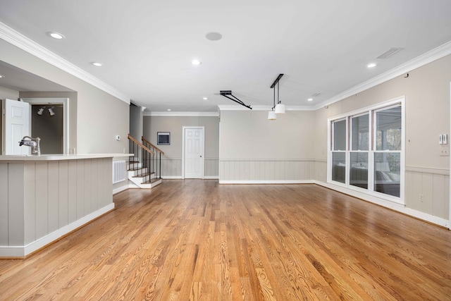 unfurnished living room with crown molding and light wood-type flooring