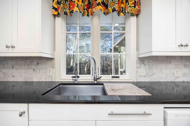 kitchen featuring sink, white cabinets, and decorative backsplash