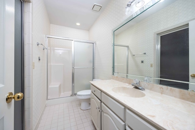 bathroom with toilet, vanity, a shower with door, and tile patterned flooring