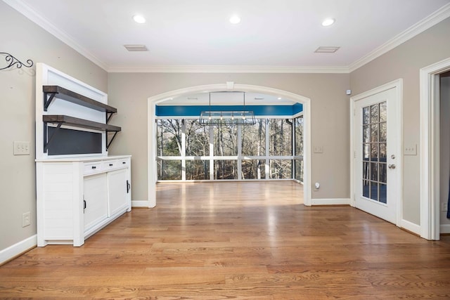 interior space featuring a notable chandelier, ornamental molding, and light wood-type flooring