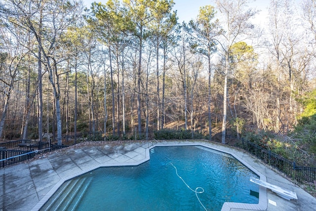 view of swimming pool with a patio and a diving board