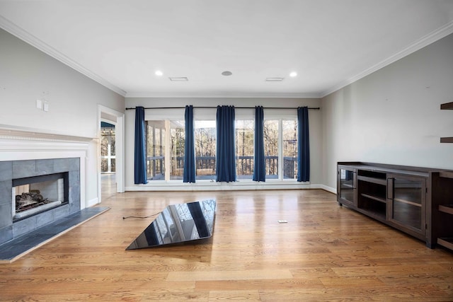 living room with crown molding, a fireplace, and light hardwood / wood-style flooring