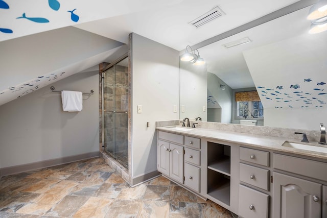 bathroom featuring walk in shower, lofted ceiling, and vanity