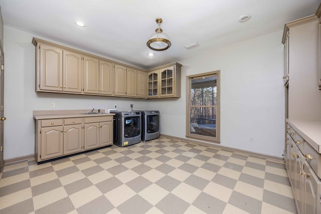 washroom featuring cabinets, separate washer and dryer, and sink