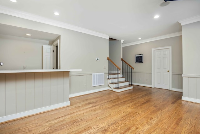 empty room with crown molding and light wood-type flooring