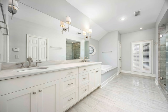 bathroom featuring vanity, lofted ceiling, and independent shower and bath