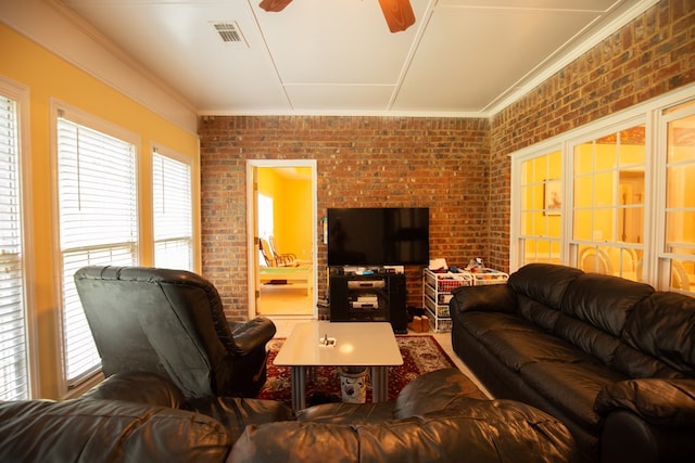 living room with ceiling fan, ornamental molding, and brick wall