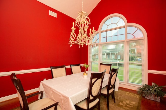 dining room featuring an inviting chandelier and vaulted ceiling