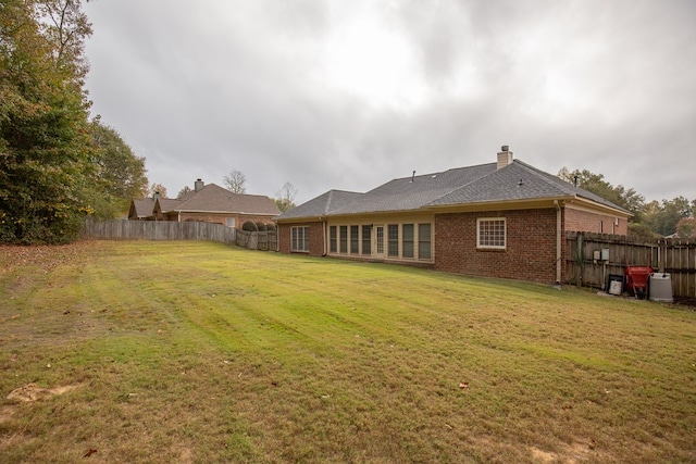 rear view of house featuring a yard