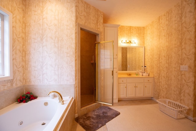 bathroom with a textured ceiling, vanity, and separate shower and tub