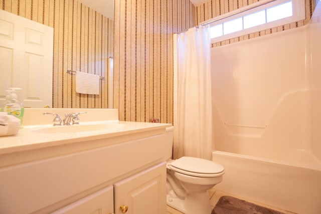 full bathroom featuring toilet, vanity, and shower / tub combo with curtain