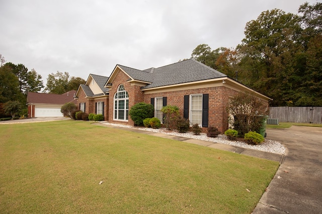 view of front of home featuring a garage, a front lawn, and central air condition unit