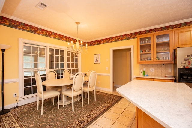 dining area featuring light tile patterned floors, a textured ceiling, an inviting chandelier, and ornamental molding