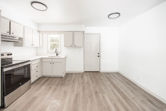 2104 Wellborn Dr, Columbus, GA 31907 - kitchen featuring electric stove, under cabinet range hood, light wood finished floors, light countertops, and white cabinetry