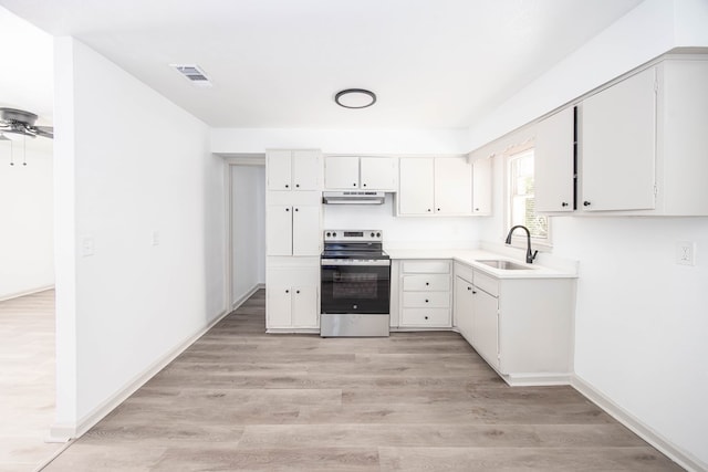 2104 Wellborn Dr, Columbus, GA 31907 - kitchen featuring stainless steel range with electric cooktop, under cabinet range hood, light countertops, white cabinetry, and light wood-style flooring