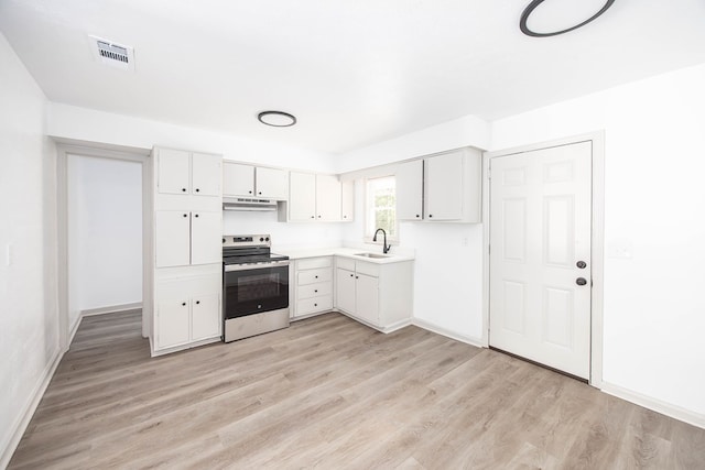 2104 Wellborn Dr, Columbus, GA 31907 - kitchen featuring stainless steel electric range, under cabinet range hood, light wood-style flooring, white cabinets, and light countertops