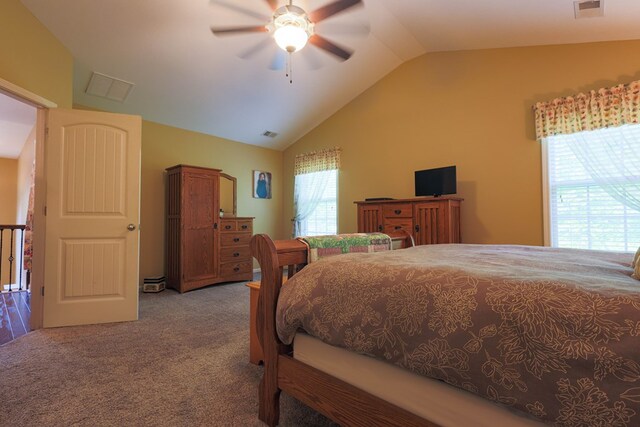 carpeted bedroom with ceiling fan, vaulted ceiling, and visible vents