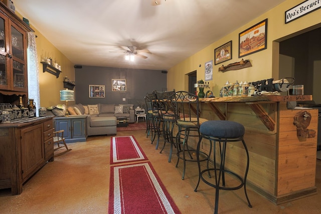 interior space with a ceiling fan and concrete flooring