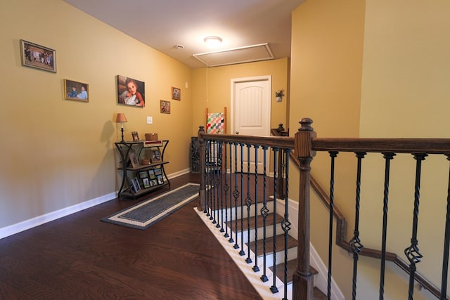 stairway featuring baseboards, attic access, and wood finished floors
