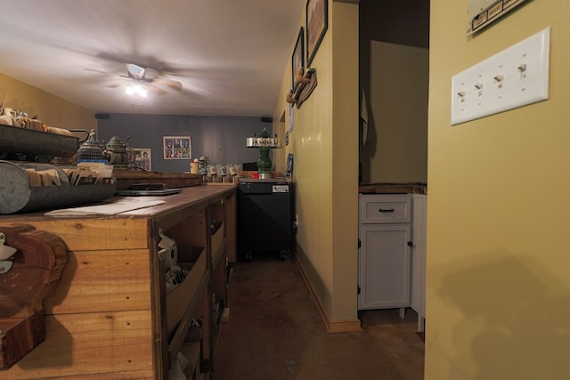 interior space featuring a peninsula, concrete floors, ceiling fan, and black dishwasher