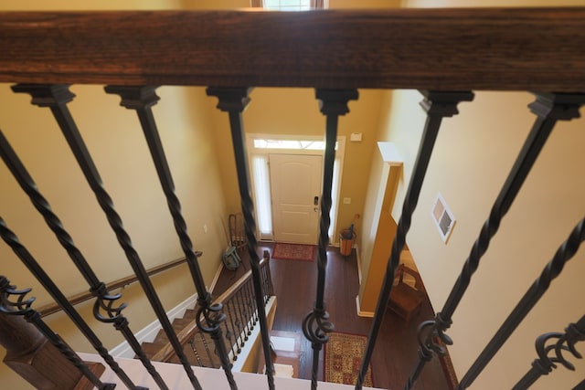 stairs featuring visible vents, baseboards, and wood finished floors