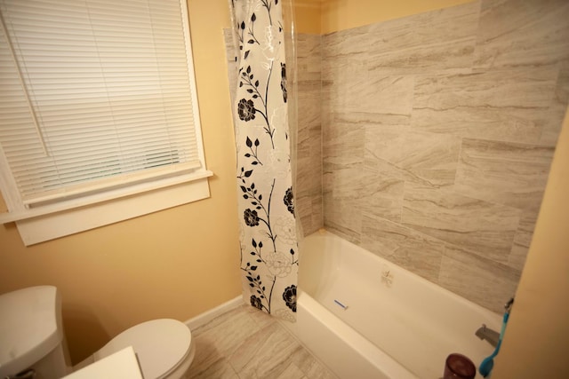 bathroom featuring shower / bath combination with curtain and toilet