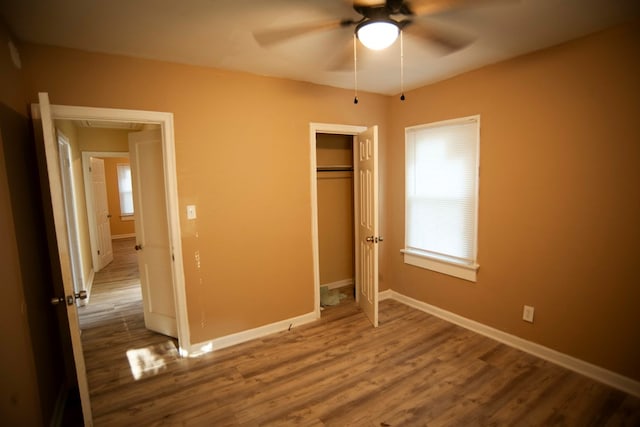 unfurnished bedroom featuring hardwood / wood-style flooring, ceiling fan, and a closet