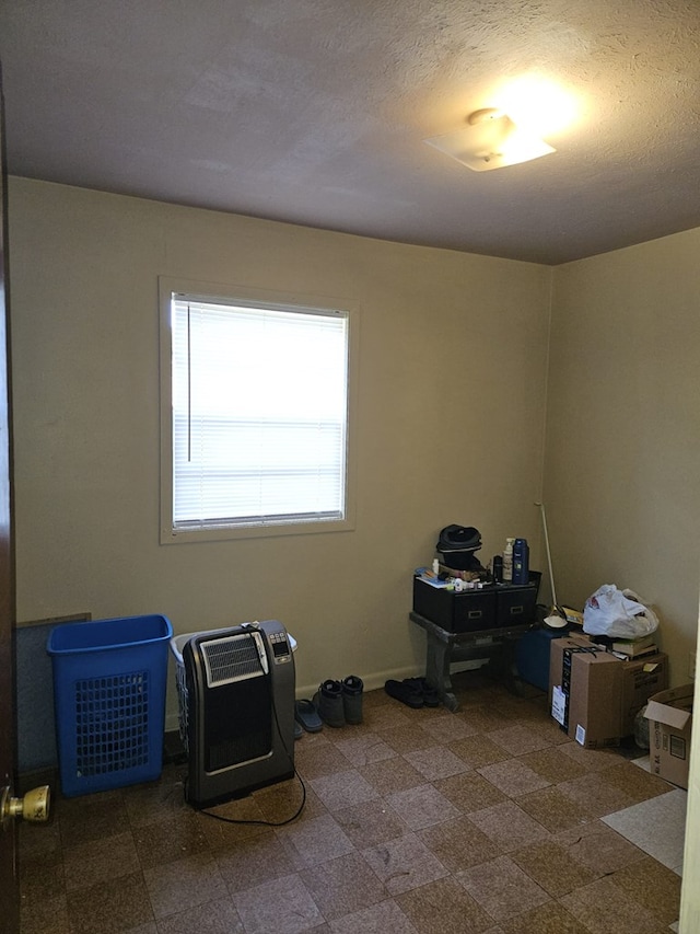 unfurnished office featuring heating unit and baseboards