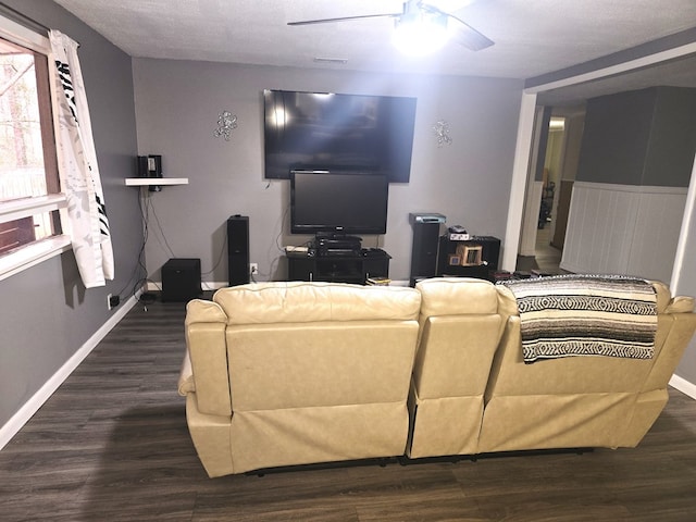 living room featuring dark wood-type flooring and ceiling fan