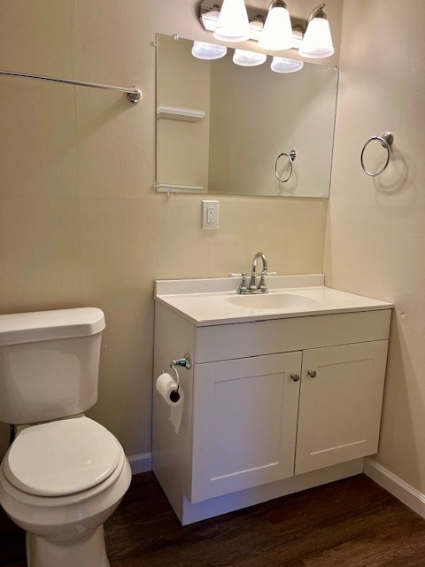 bathroom featuring vanity, hardwood / wood-style flooring, and toilet