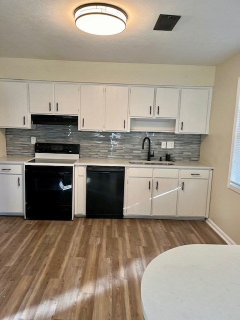 kitchen featuring black appliances, white cabinetry, light hardwood / wood-style flooring, and tasteful backsplash