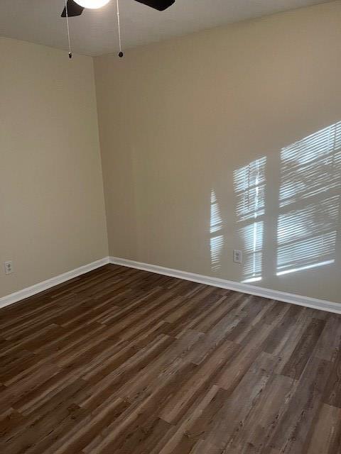 unfurnished room with ceiling fan and dark hardwood / wood-style flooring