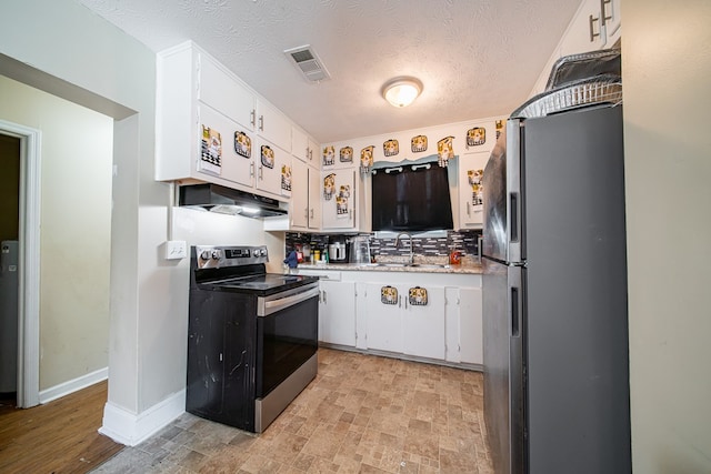 1605 39th St, Columbus, GA 31904 - kitchen featuring appliances with stainless steel finishes, white cabinetry, light countertops, under cabinet range hood, and decorative backsplash