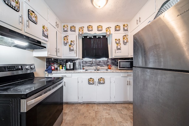 1605 39th St, Columbus, GA 31904 - kitchen featuring stainless steel appliances, white cabinets, extractor fan, and a textured ceiling