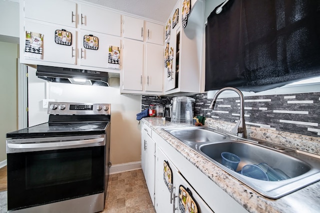 1605 39th St, Columbus, GA 31904 - kitchen with stainless steel range with electric cooktop, exhaust hood, backsplash, white cabinets, and light countertops