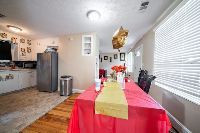 1605 39th St, Columbus, GA 31904 - dining room with light wood finished floors and a textured ceiling