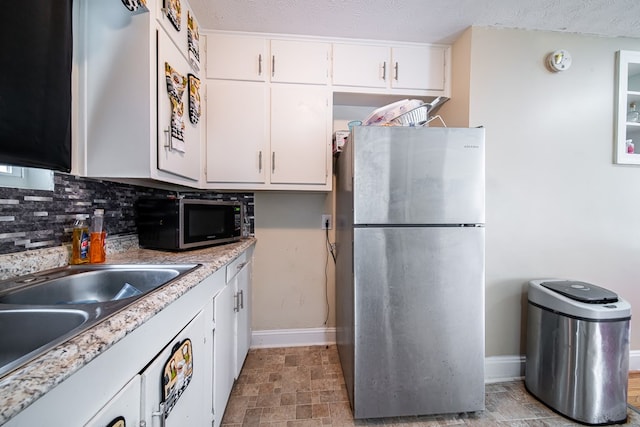 1605 39th St, Columbus, GA 31904 - kitchen featuring appliances with stainless steel finishes, backsplash, white cabinetry, and light countertops