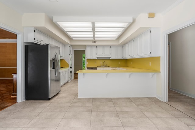 1425 Dartmouth Rd, Columbus, GA 31904 - kitchen featuring stainless steel refrigerator with ice dispenser, a peninsula, a sink, light countertops, and light tile patterned flooring