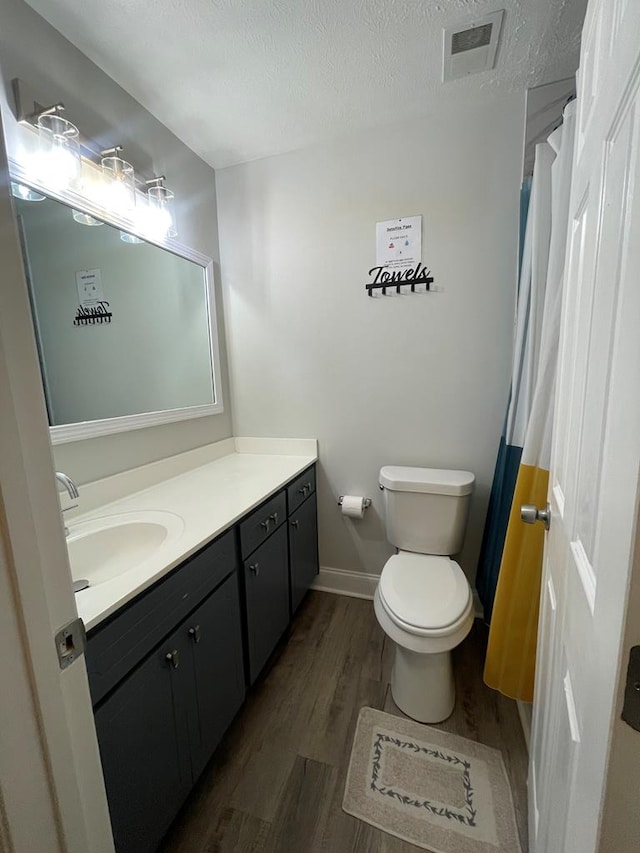 1023 Maridele Dr, Columbus, GA 31904 - bathroom with wood finished floors, vanity, toilet, a textured ceiling, and baseboards