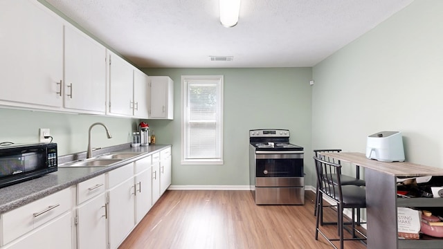 205 19th St, Phenix City, AL 36867 - kitchen with electric stove, black microwave, a sink, and light wood-style floors