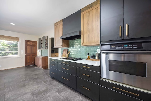 2618 Habersham Ave, Columbus, GA 31906 - kitchen featuring stainless steel oven, custom range hood, decorative backsplash, light countertops, and black cooktop