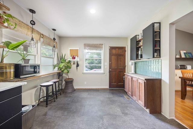 2618 Habersham Ave, Columbus, GA 31906 - kitchen featuring stainless steel microwave, open shelves, healthy amount of natural light, and light countertops