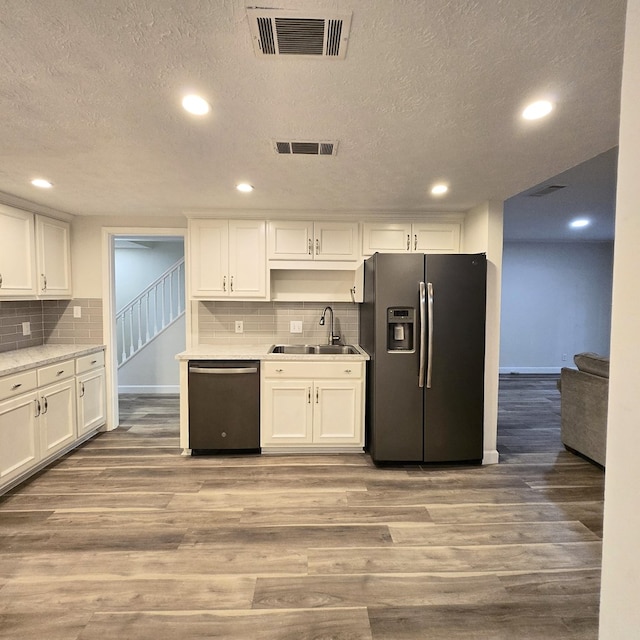 kitchen featuring stainless steel appliances, light wood-type flooring, visible vents, and a sink