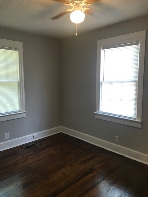 unfurnished room featuring ceiling fan and dark wood-type flooring