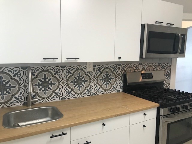 kitchen featuring sink, white cabinets, and appliances with stainless steel finishes