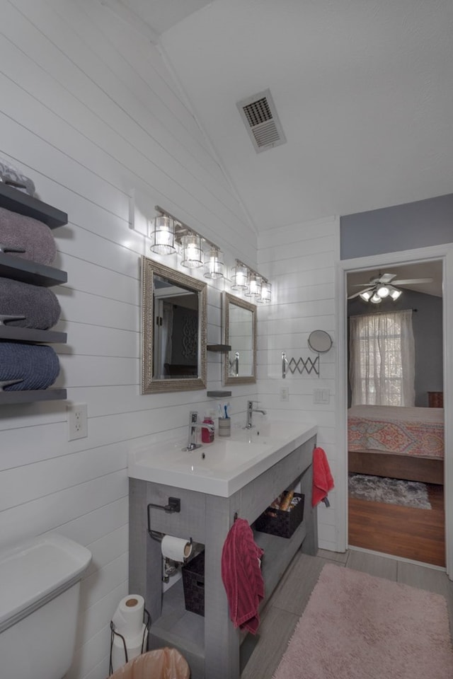 bathroom with vaulted ceiling, ensuite bath, toilet, tile patterned floors, and vanity