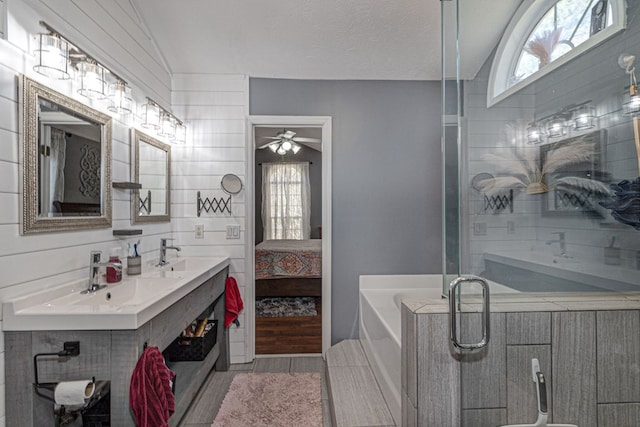 bathroom featuring healthy amount of natural light, ensuite bathroom, ceiling fan, and a garden tub
