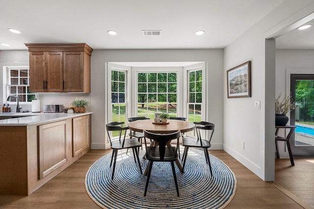 dining area featuring a wealth of natural light, light wood-type flooring, and visible vents
