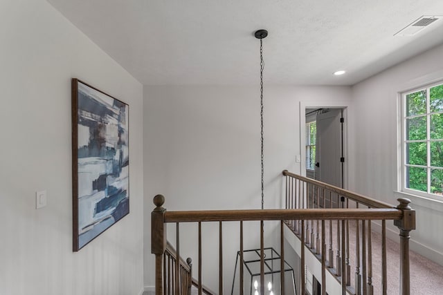 hallway with carpet flooring, an upstairs landing, visible vents, baseboards, and recessed lighting